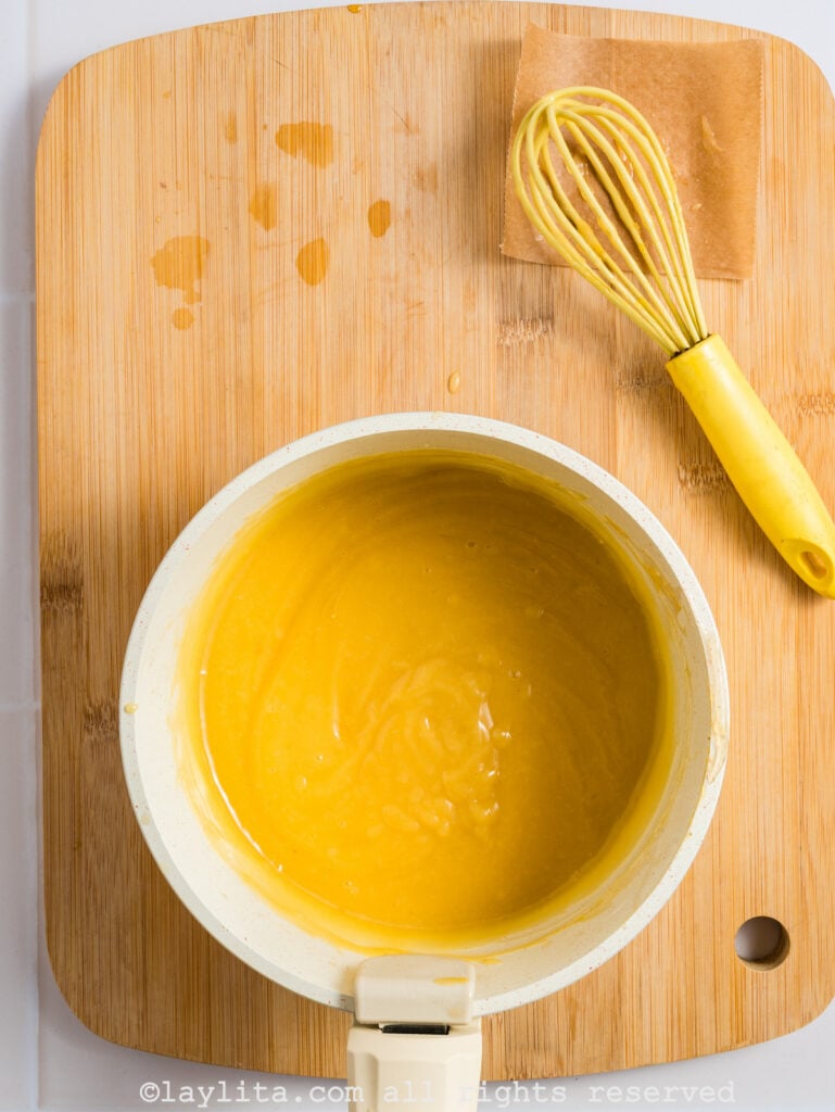 Lemon custard in a pot on a wood board