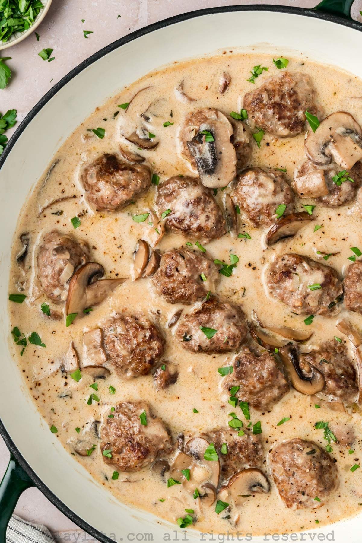 Close up of beef stroganoff meatballs in a creamy sauce in a skillet