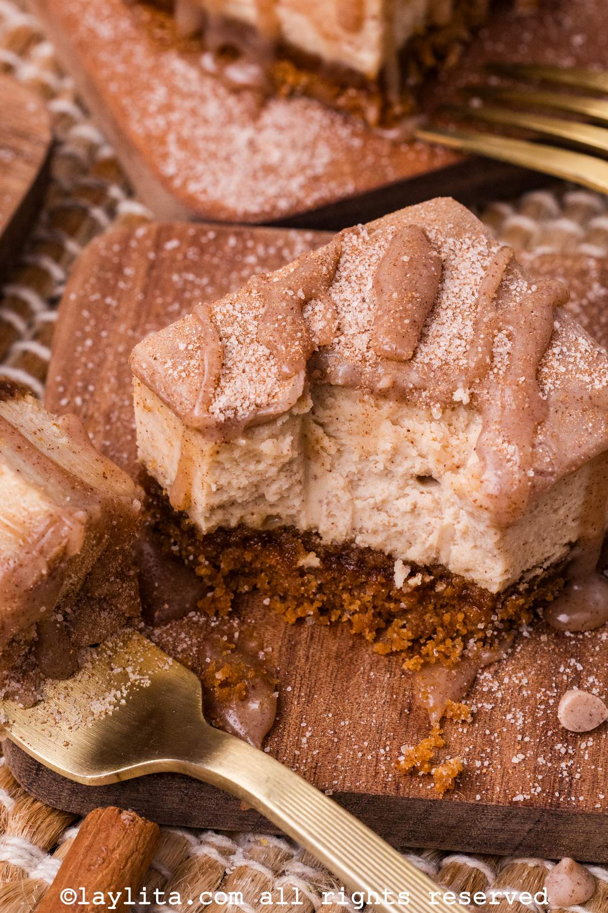 A cheesecake bar with a bite missing and a fork on the side with the missing bit