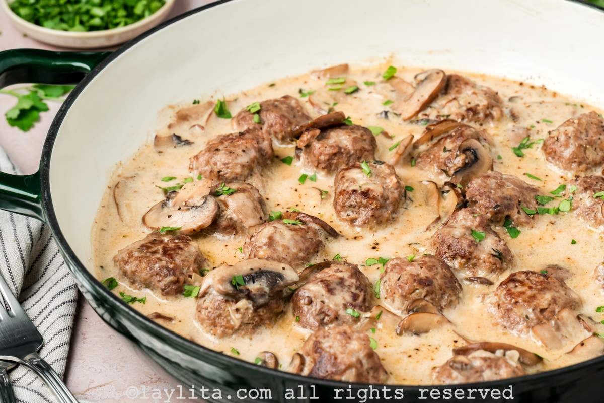 Close up of beef stroganoff meatballs in a cast iron skillet from the side
