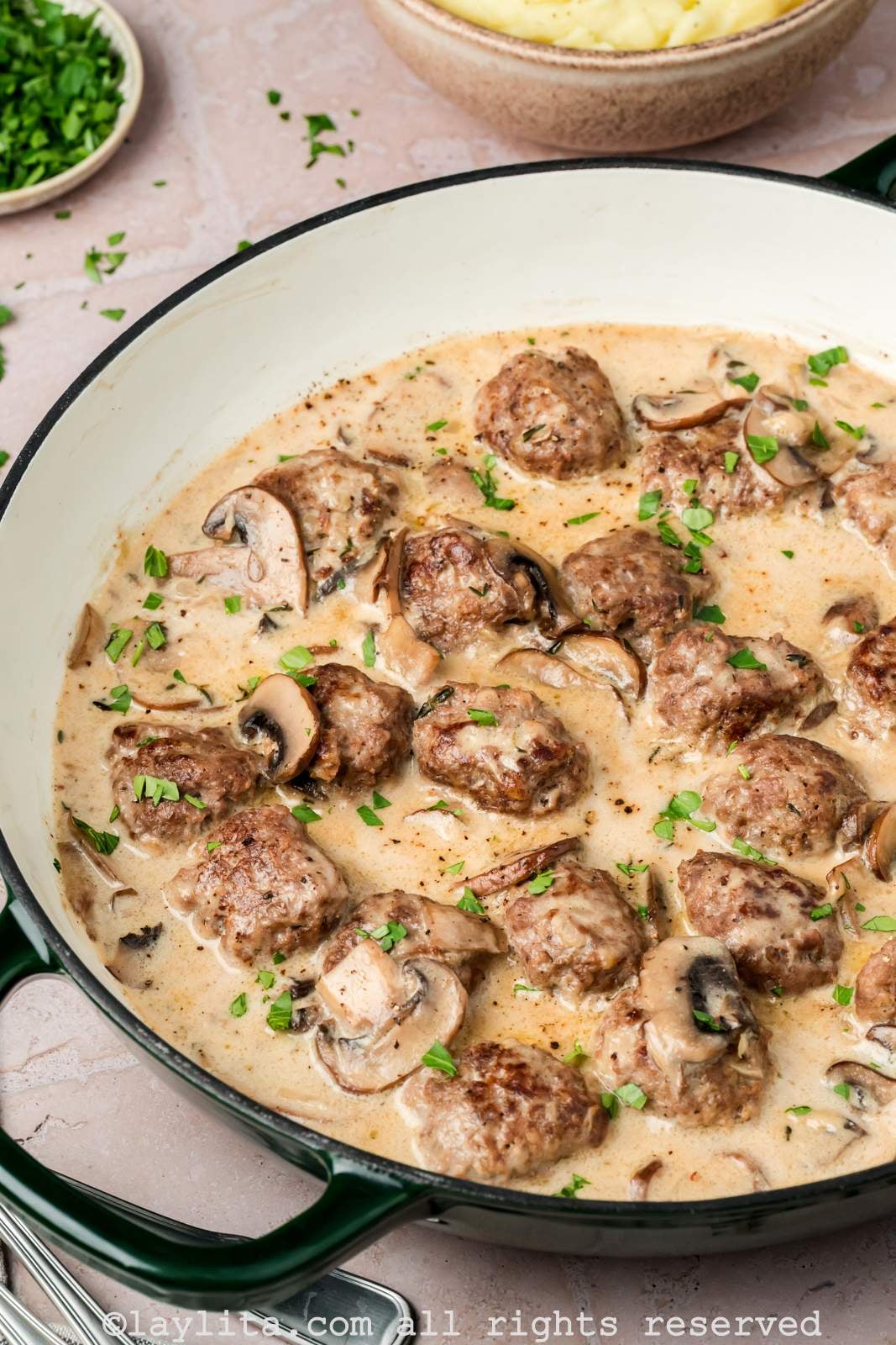 Beef meatballs cooking in a skillet with stroganoff sauce