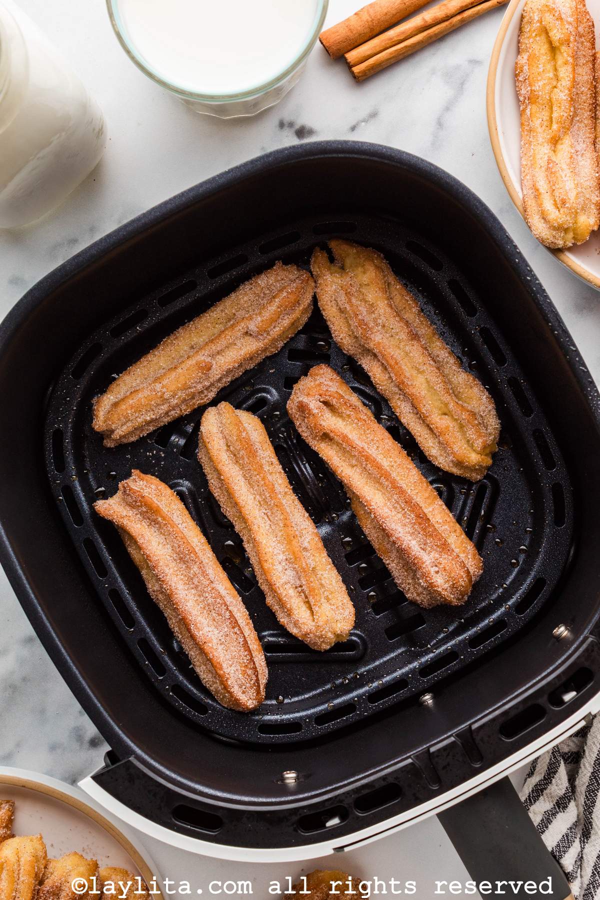 Overhead view of five churros in the air fryer basket
