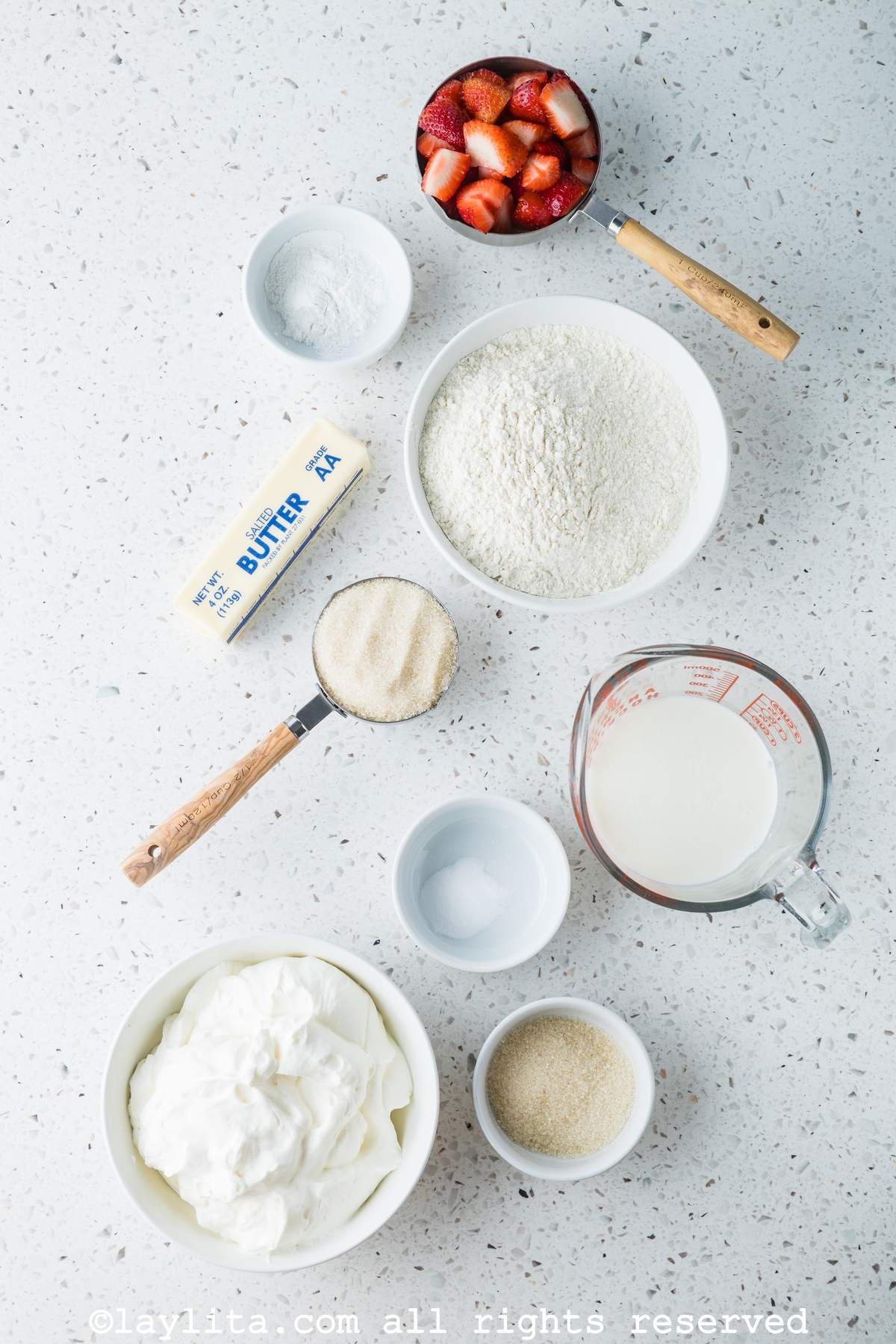 Ingredients needed to make strawberry shortcakes on a kitchen counter.