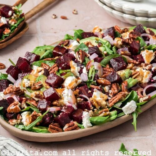Overhead shot of a beet salad with feta cheese, avocadoes and pecans on a serving platter