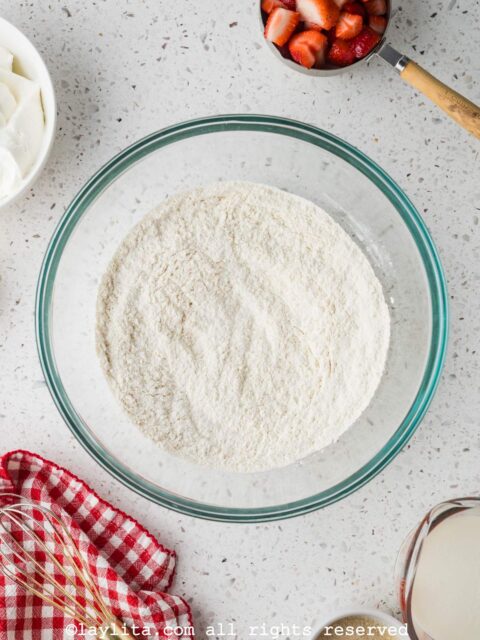 Shortcake biscuit dough being prepared in a glass bowl on a kitchen counter