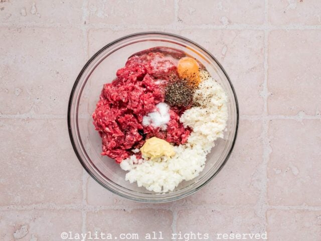 Ingredients for beef meatballs in a glass bowl