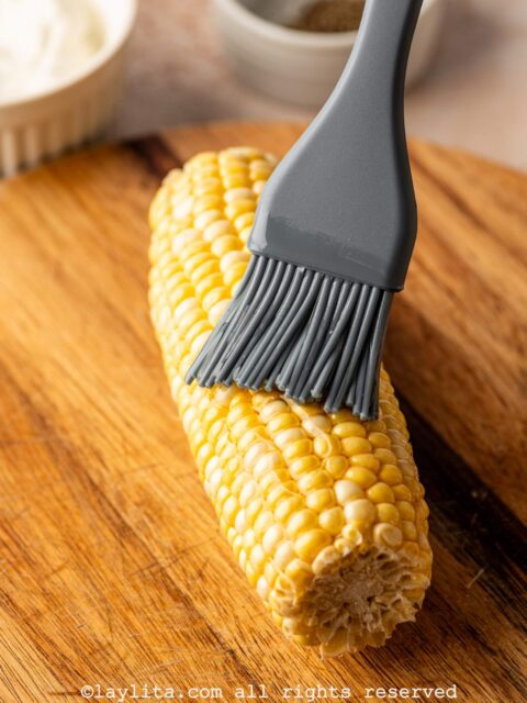 Brushing an ear of corn with oil