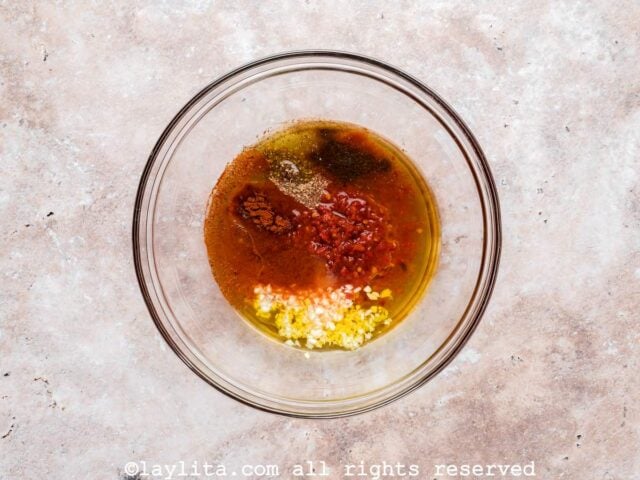 Ingredients for honey harissa marinade in a glass bowl