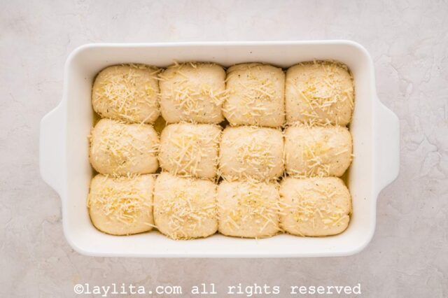 Unbaked dinner rolls rising in a baking dish
