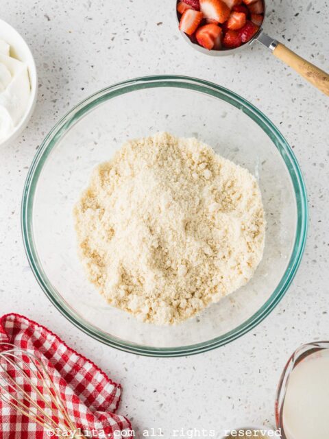 Shortcake biscuit dough being prepared in a glass bowl on a kitchen counter