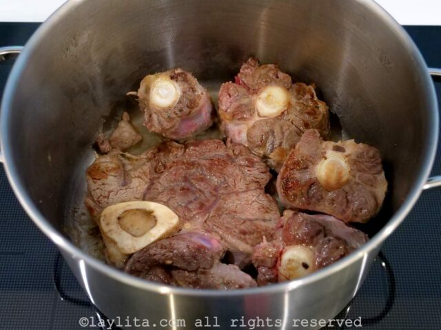 Beef shank and oxtail being browned in a pot