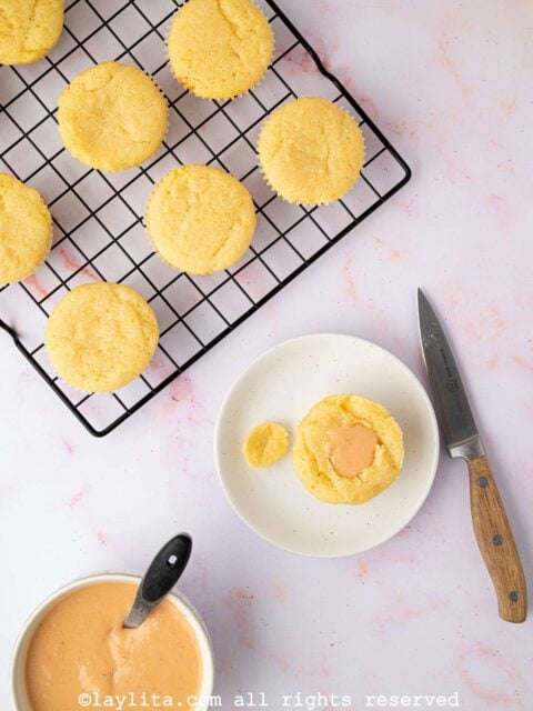 A cupcake being filled with strawberry lemon curd