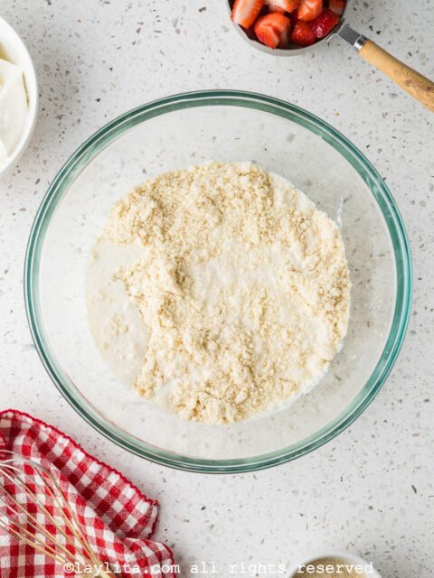 Shortcake biscuit dough being prepared in a glass bowl on a kitchen counter