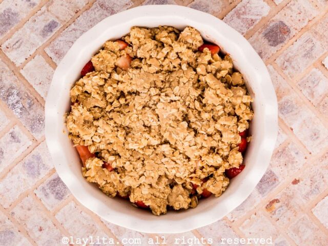 Strawberry crisp in a white pie pan before baking
