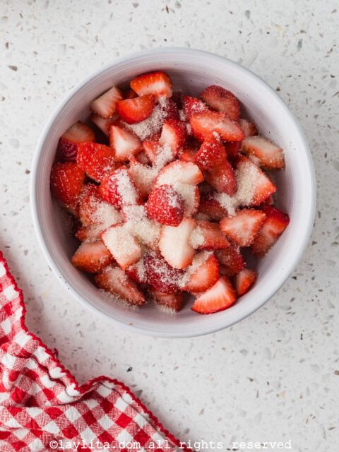 A bowl with cut strawberries sprinkled with sugar