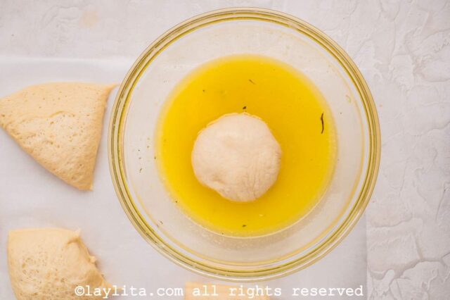 A ball of dough being dipped in garlic butter