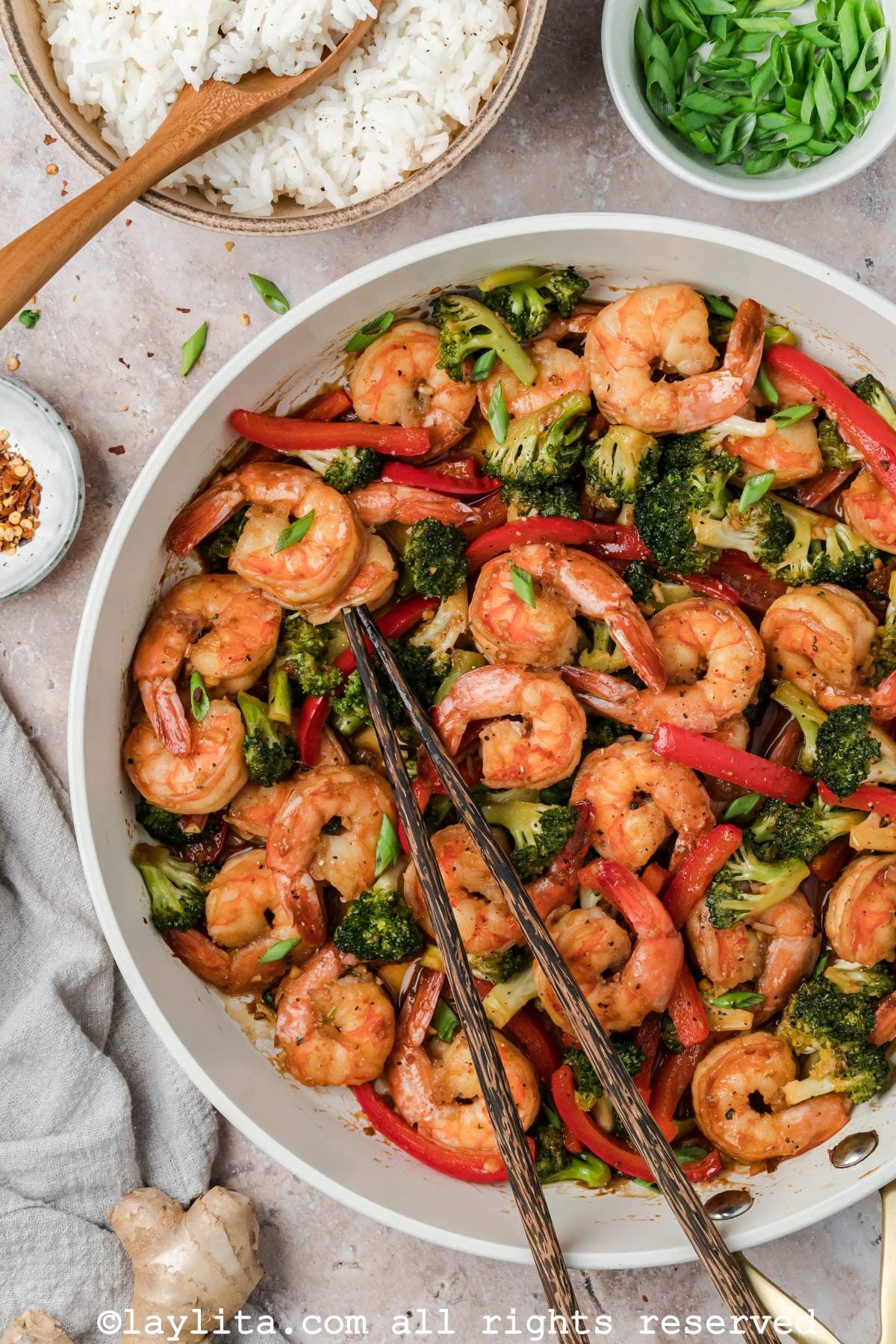 Overhead shot of shrimp broccoli stir fry in a skillet with chopsticks.