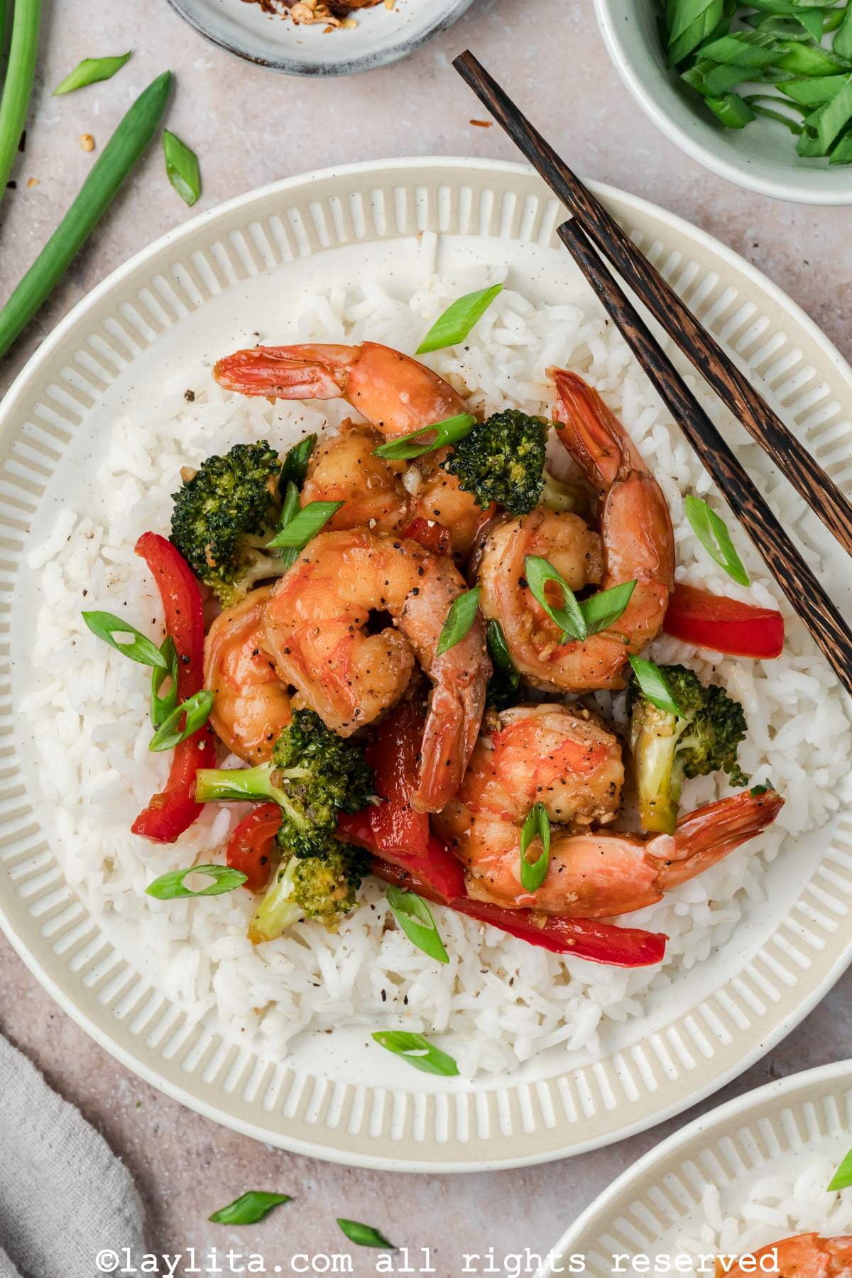 Close up of a bowl with rice and shrimp broccoli stir fry on top. 