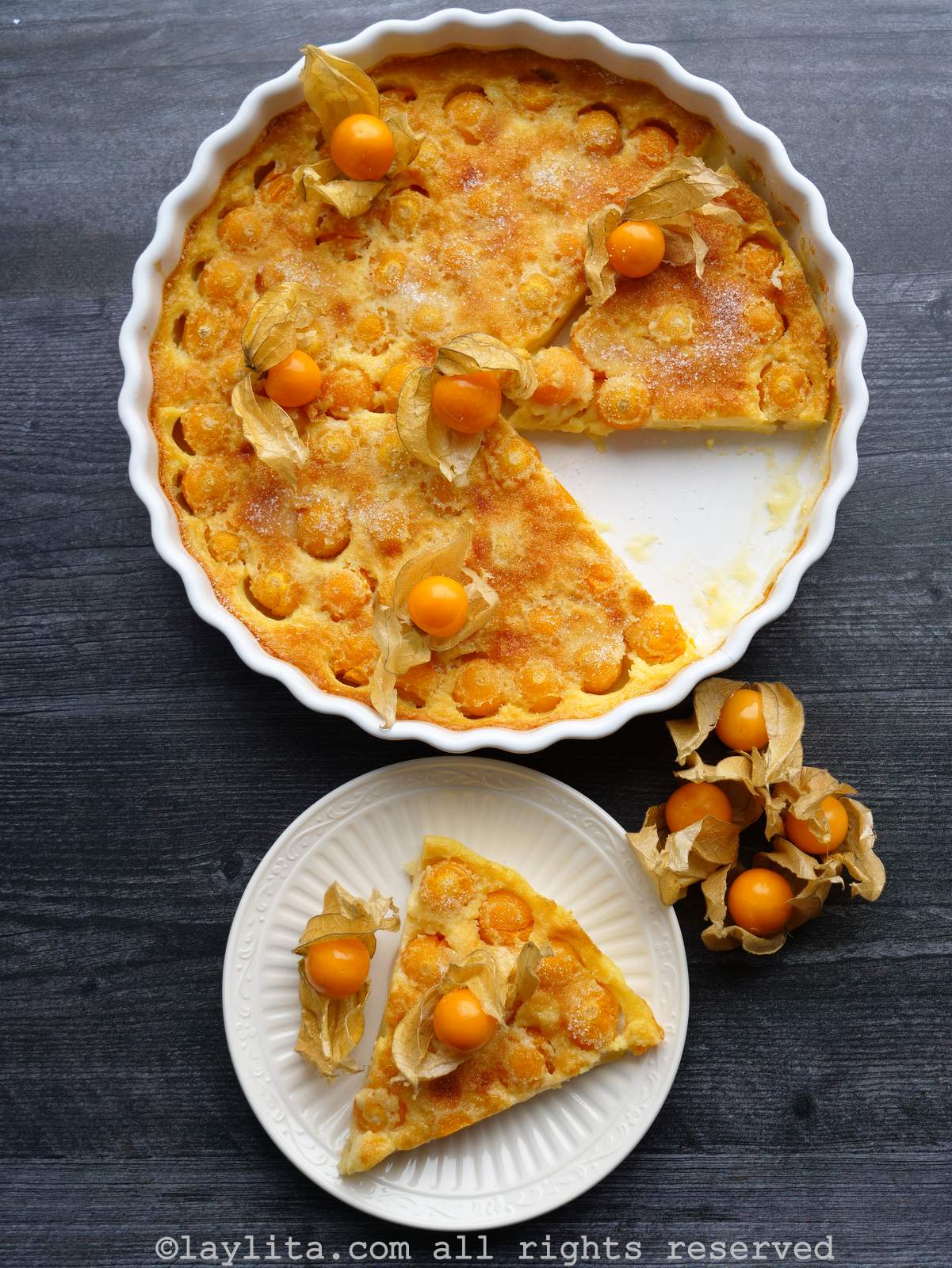 Overhead shot of uvilla clafoutis in a baking dish next to a slice of it on a plate.
