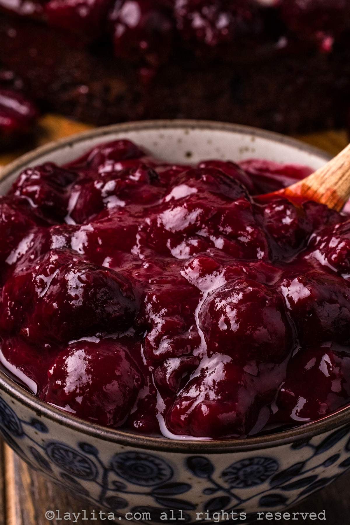 Closeup of cherry compote in a bowl with a spoon