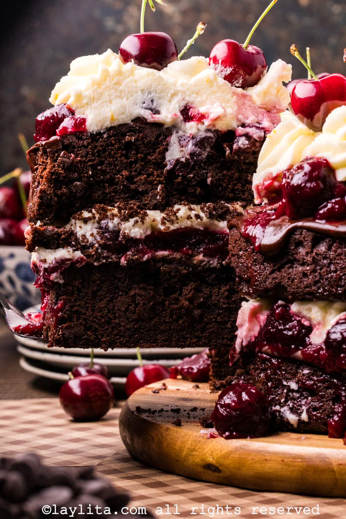 Closeup of a layered Black Forest cake with a slice being removed