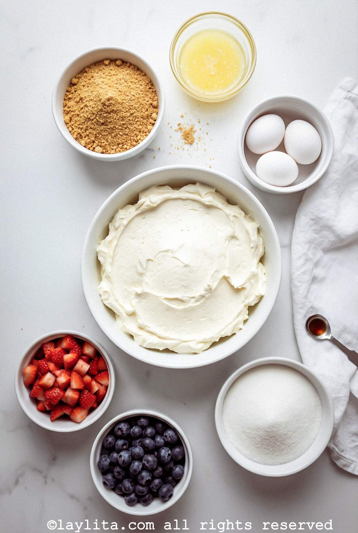 Ingredients for Mini cheesecakes with berry topping sauce on a kitchen counter
