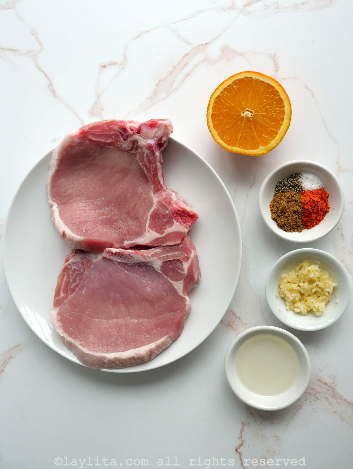 Ingredients for achiote marinated pork chops on a kitchen counter