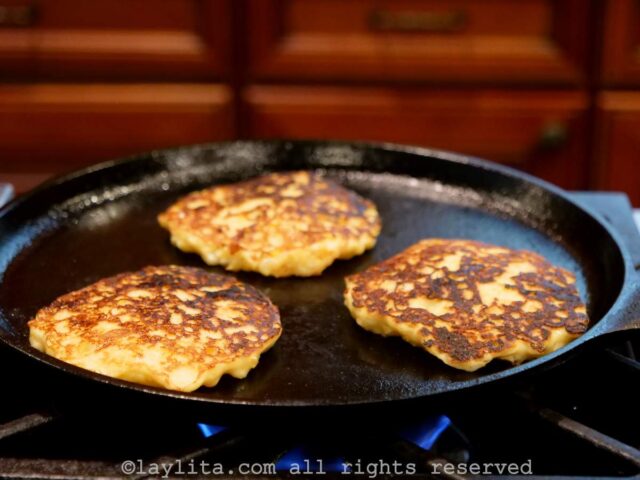 Corn fritter pancakes cooking on a skillet