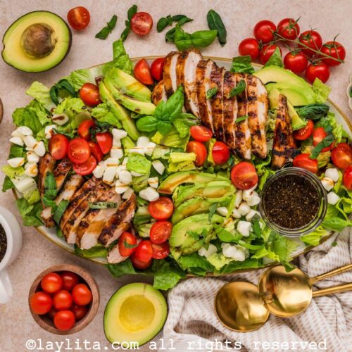 Overhead shot of a large grilled chicken caprese salad on a serving platter