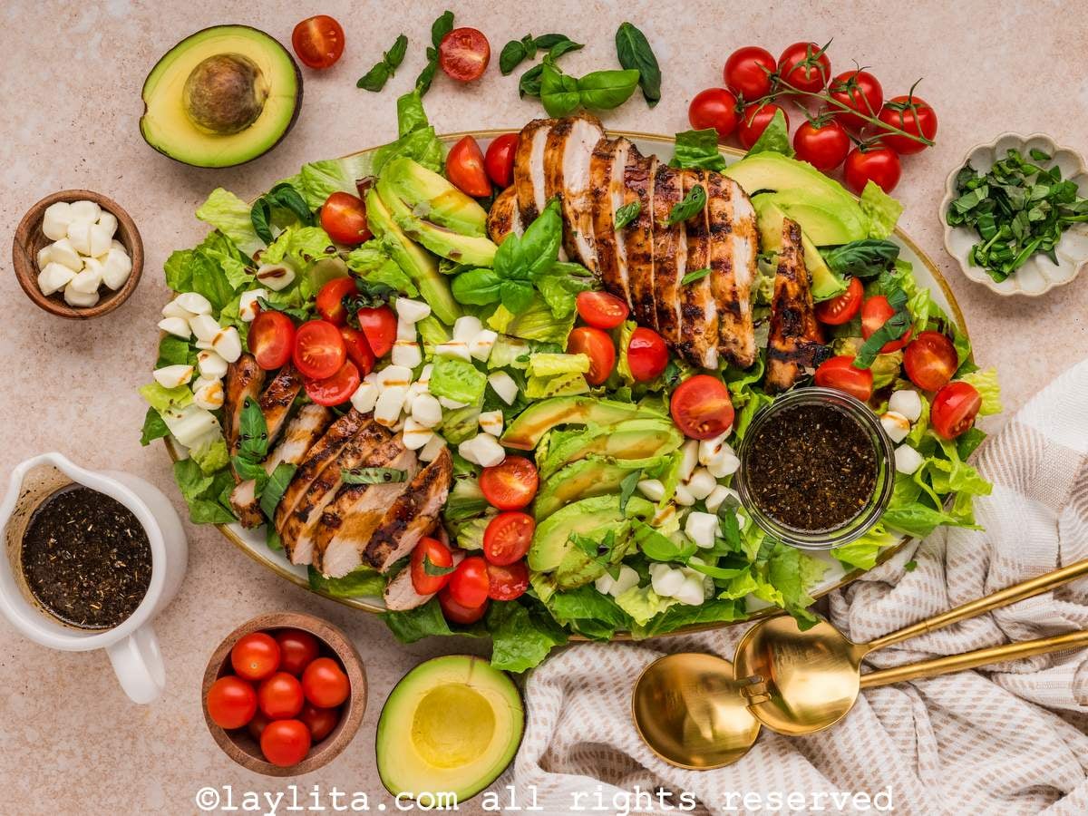 Overhead shot of a large grilled chicken caprese salad on a serving platter