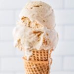Side view of a scoop of cinnamon ice cream on a cone.