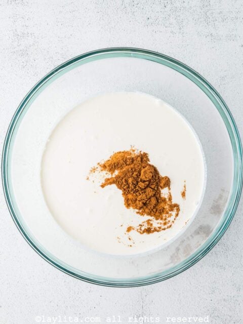 Milk, cream, brown sugar and cinnamon in a glass bowl