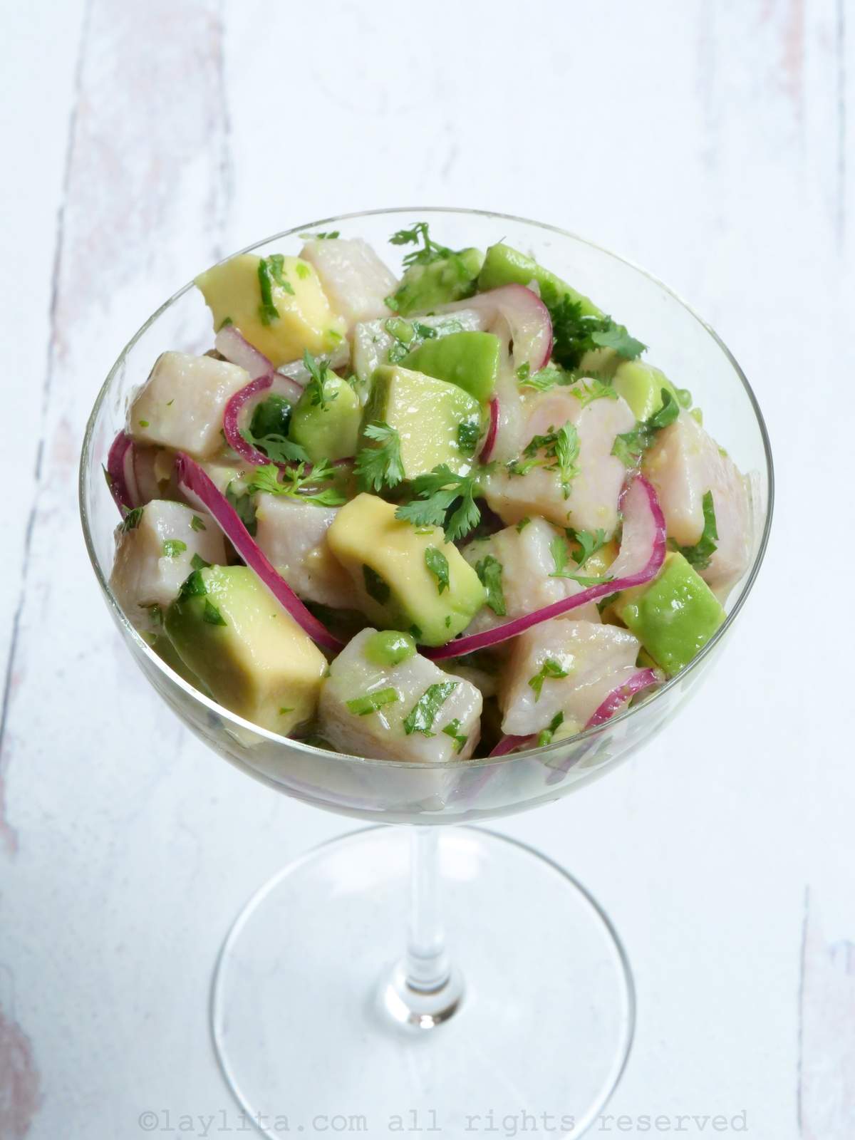 Side view of hamachi avocado ceviche served in a tall glass
