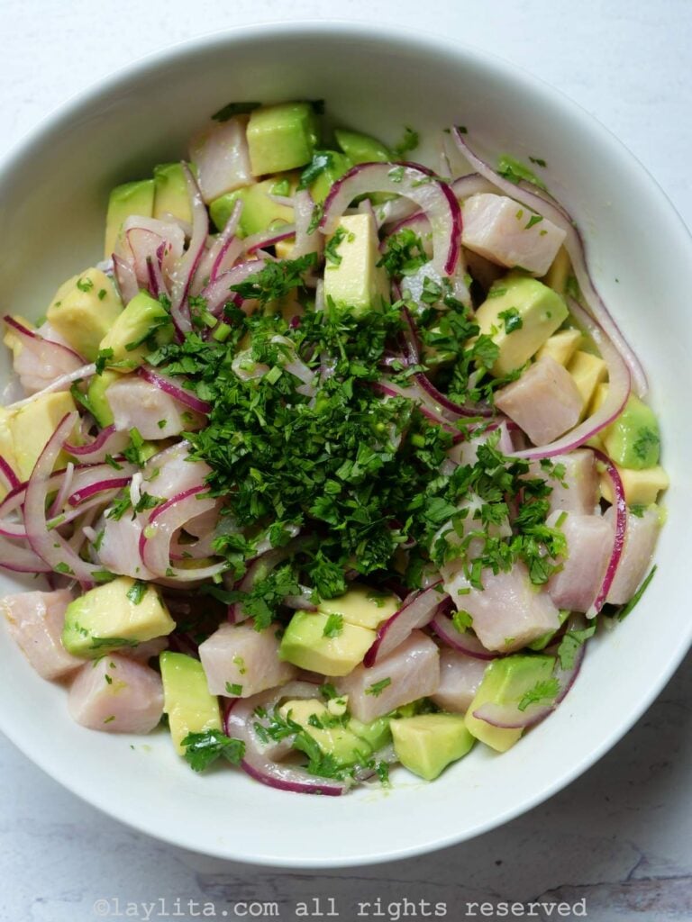 Bowl of hamachi avocado ceviche after it is all mixed together with chopped cilantro on top