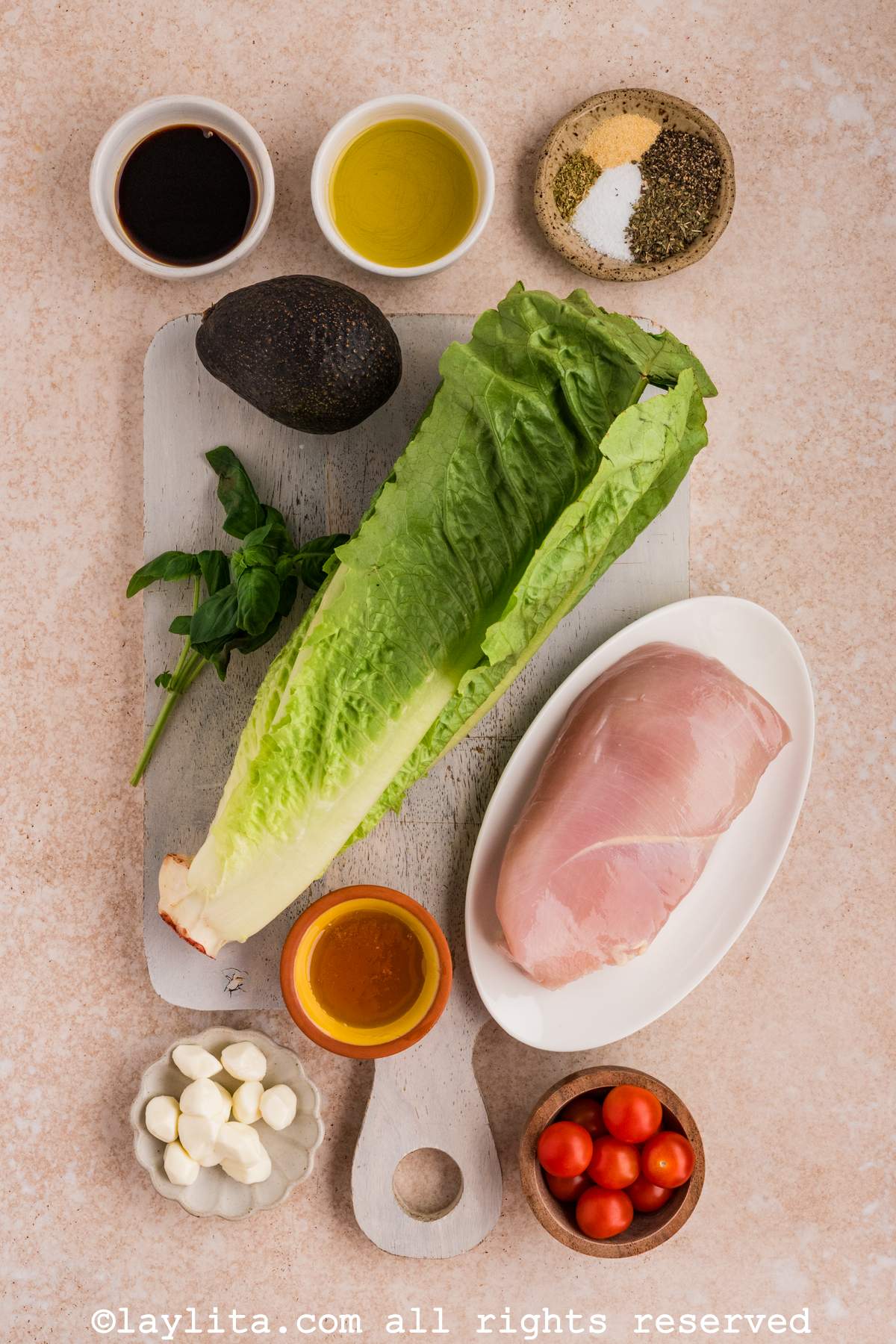 Overhead shot of ingredients needed to make grilled chicken caprese salad on a kitchen counter