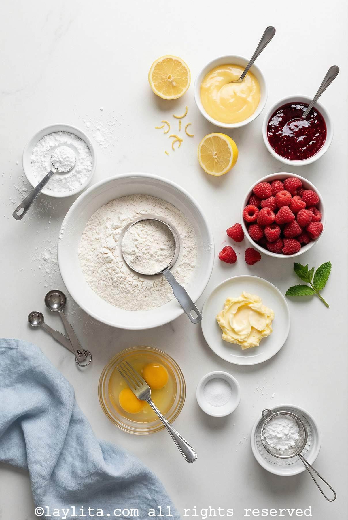 Ingredients for raspberry lemon tartlets on a white countertop