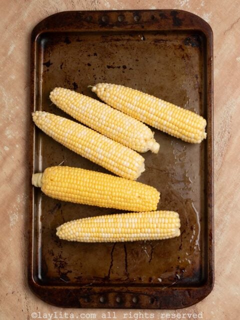 Five ears of corn on a baking platter