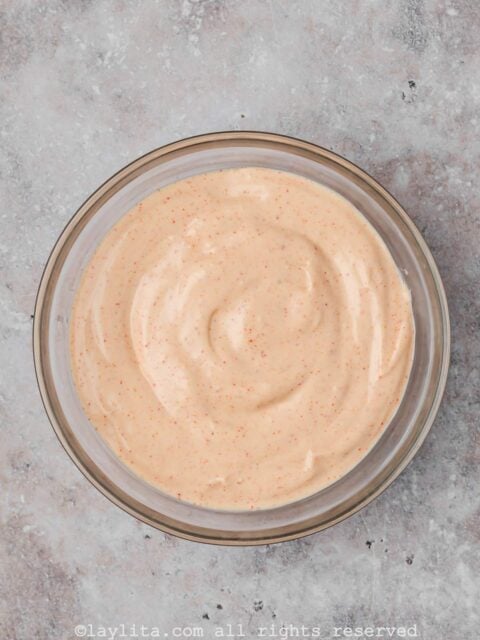 A bowl of Baja sauce for tacos in a glass bowl on a concrete counter