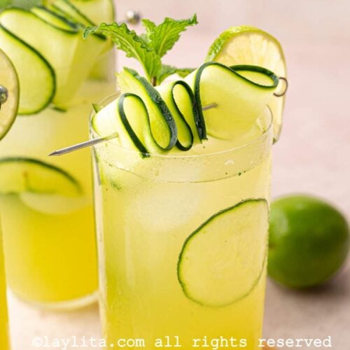 Cropped view of three glasses filled the cucumber lime mint agua fresca and garnished with cucumber ribbons
