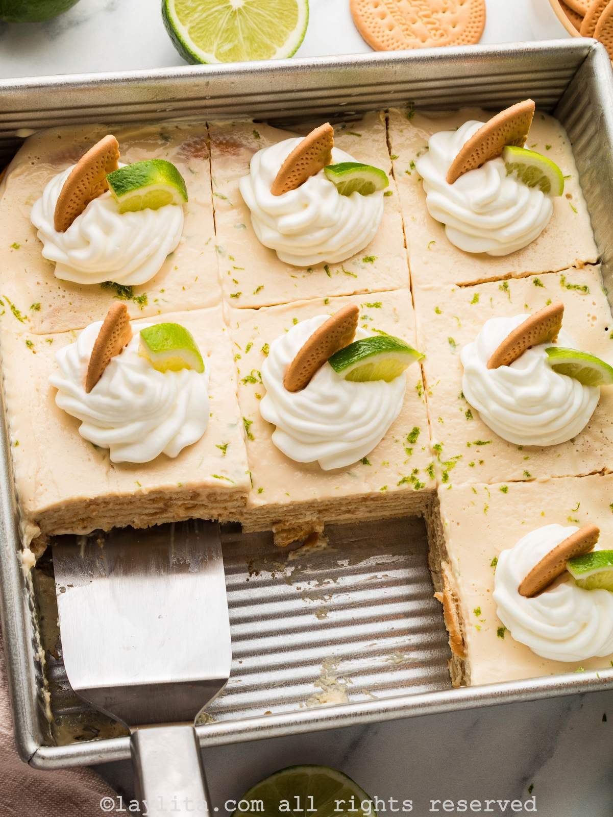 Overhead shot of a carlota de limon in a baking dish with two slices missing