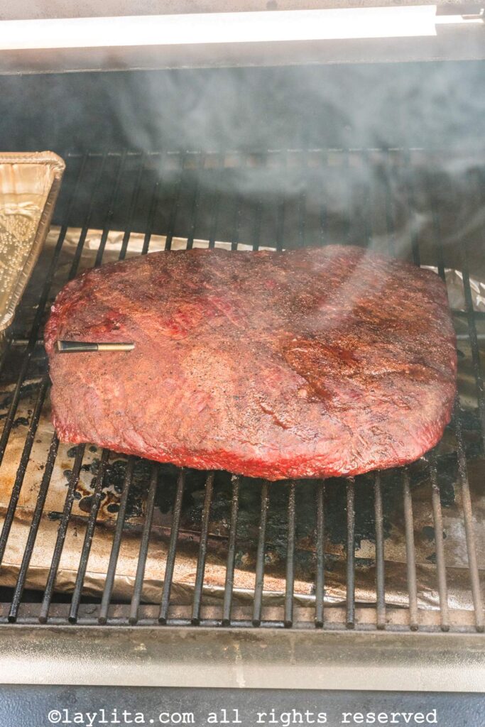 View of a beef brisket on the grill during cooking