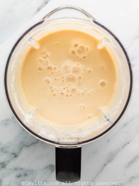 Lime juice, evaporated milk, sweetened condensed milk, and vanilla in a blender after blending