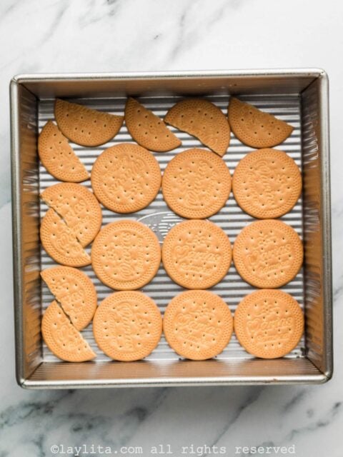 A layer of cookies on the bottom of a square baking mold