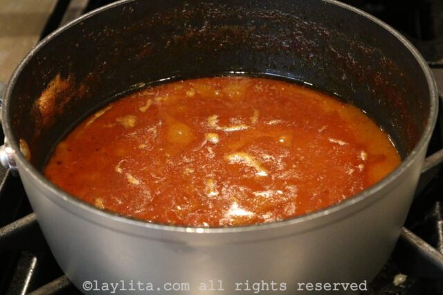 A red sauce cooking in a pan on the stovetop