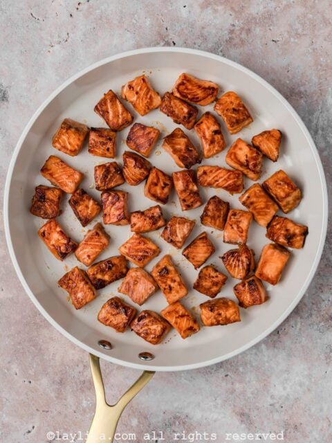 Overhead view of crispy salmon bites in a skillet