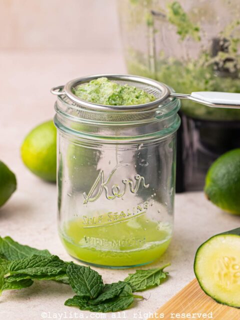 Cucumber lime mint mix being strained