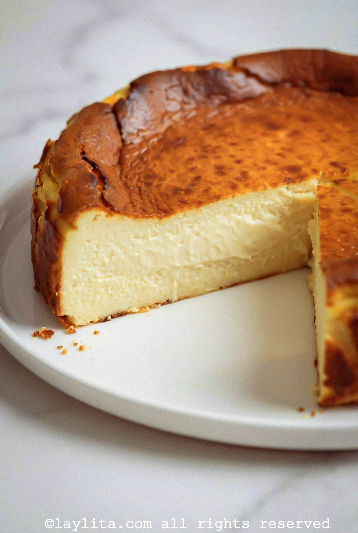 Side view of a basque cheesecake with a slice missing to show the soft center