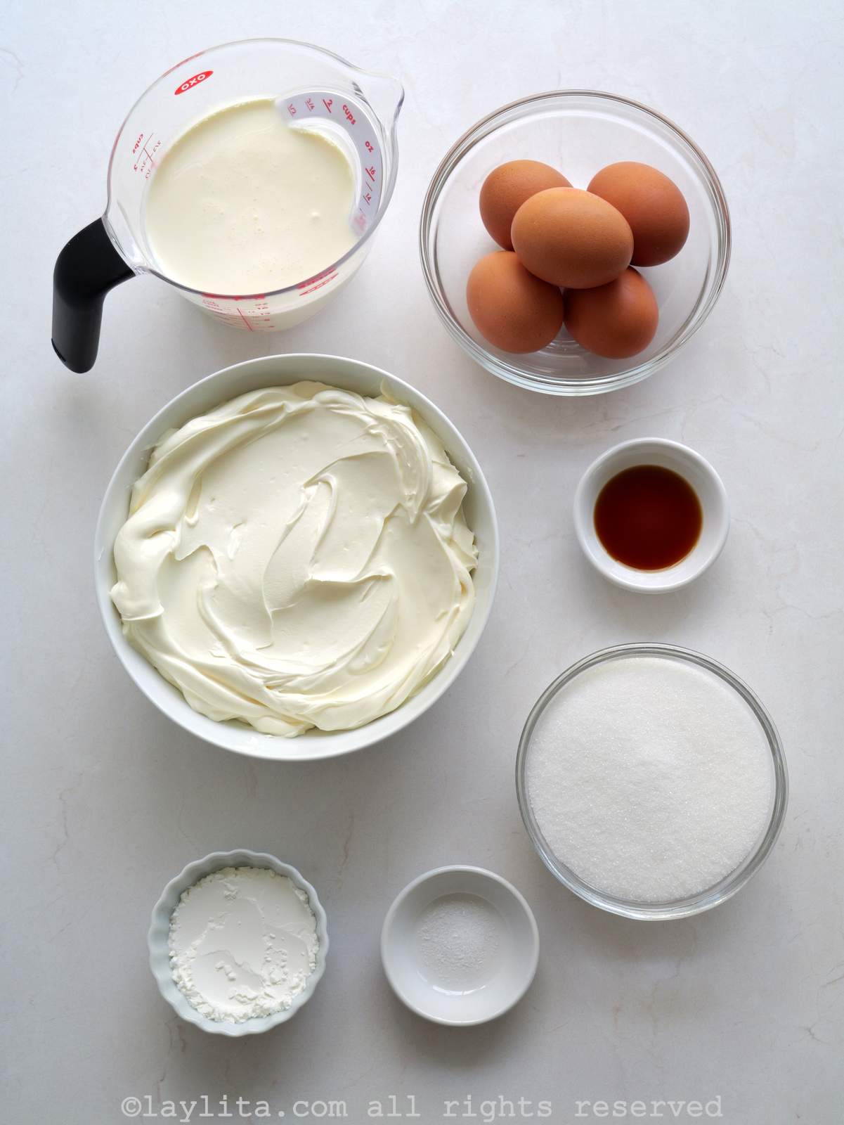 Ingredients needed to make basque cheesecake on a kitchen counter.