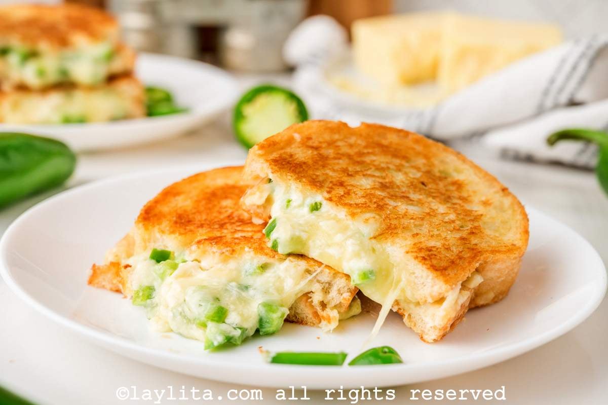 Two halves of a jalapeño popper grilled cheese leaning on each other on a plate