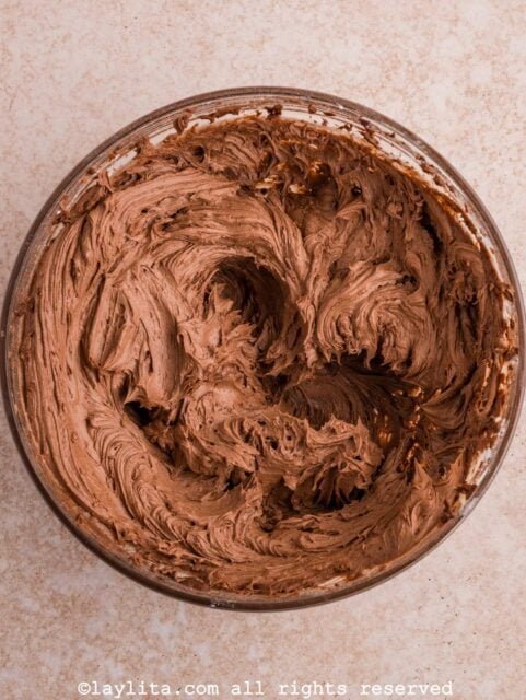 A bowl full of fluffy creamy chocolate frosting